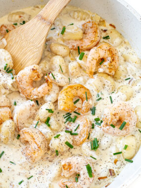 Shrimp and gnocchi in a creamy sauce in a skillet.