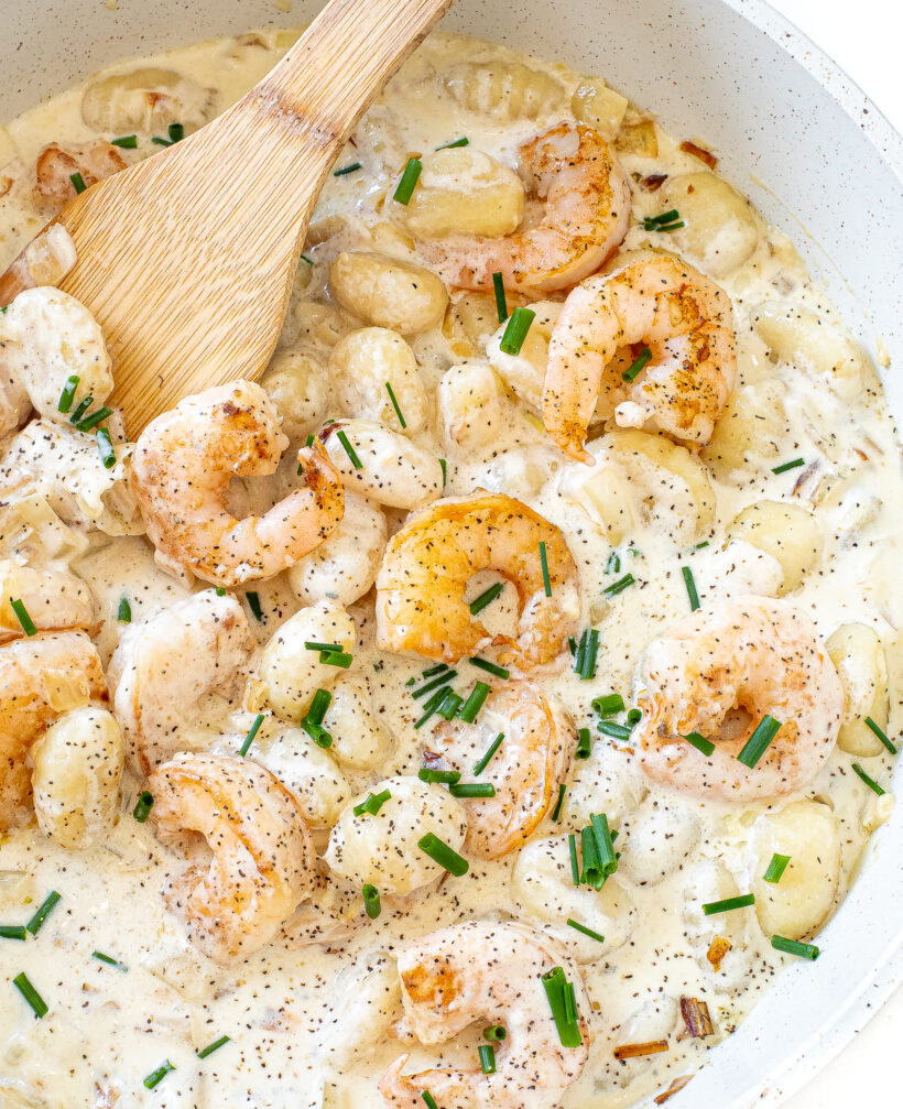 Shrimp and gnocchi in a creamy sauce in a skillet.