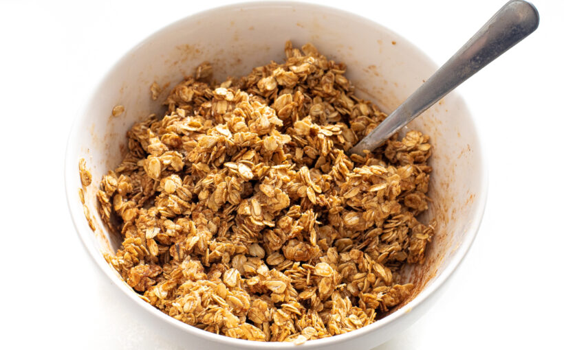 Oats mixture being mixed in a white mixing bowl.