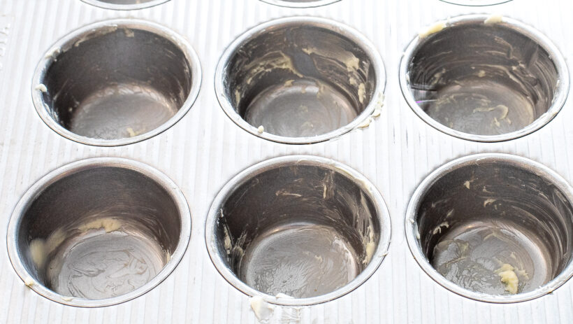 Muffin tin that has been greased with butter. 