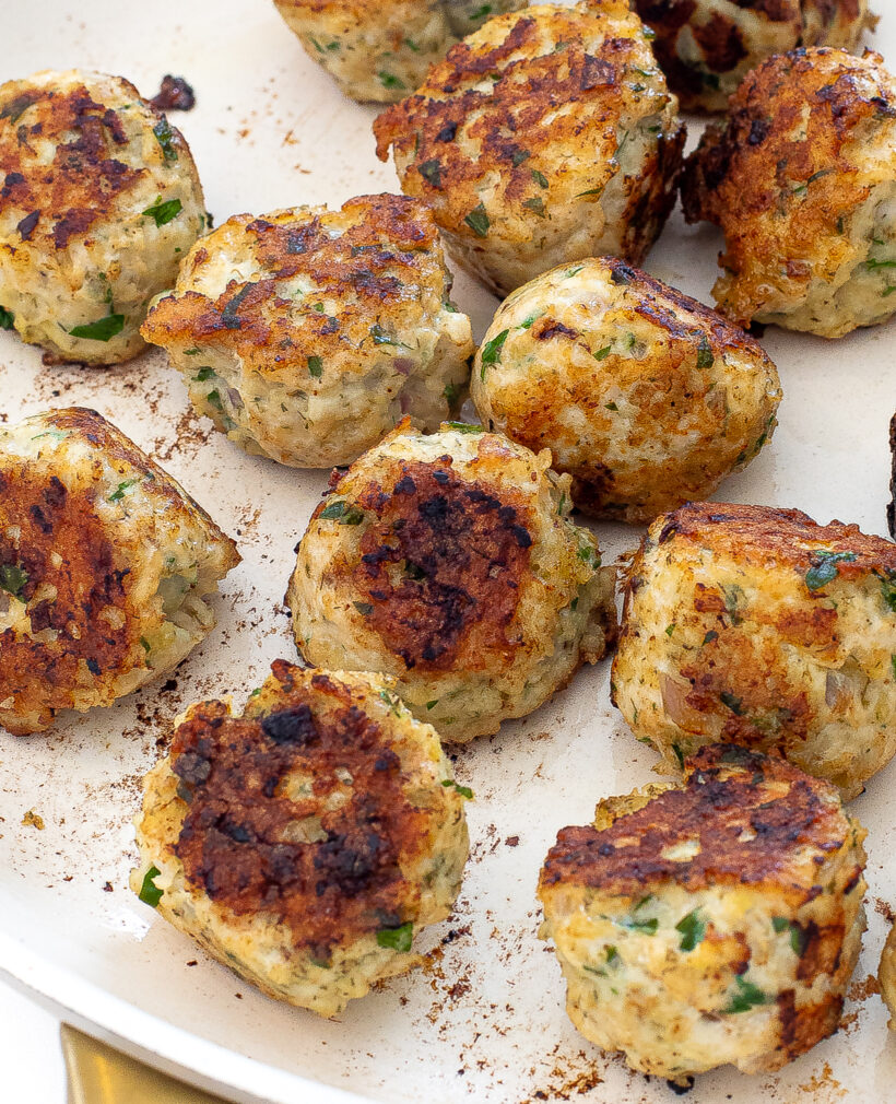 Greek meatballs being cooked in a skillet.