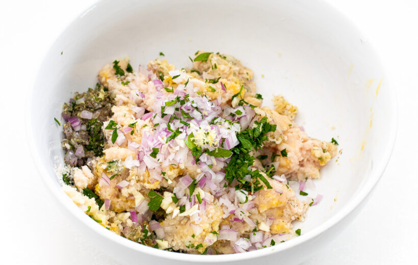 Ingredients for chicken meatballs in a mixing bowl.