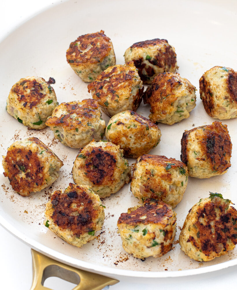 Greek chicken meatballs after being cooked in a skillet.
