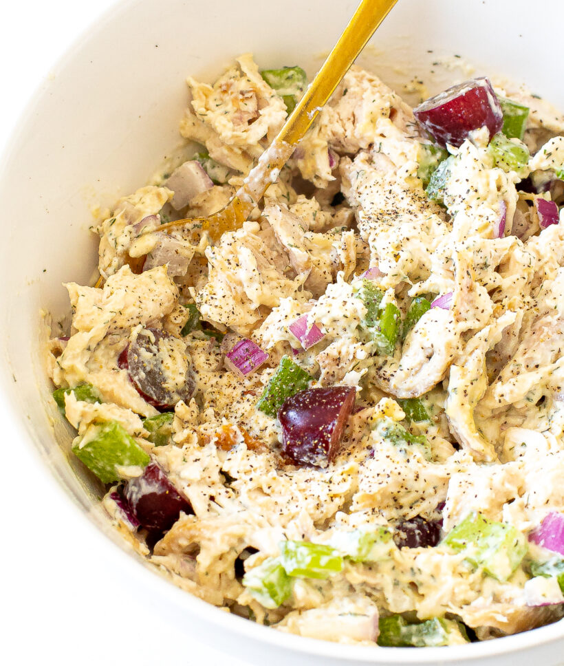 Close up shot of chicken salad in the serving bowl topped with pepper. 