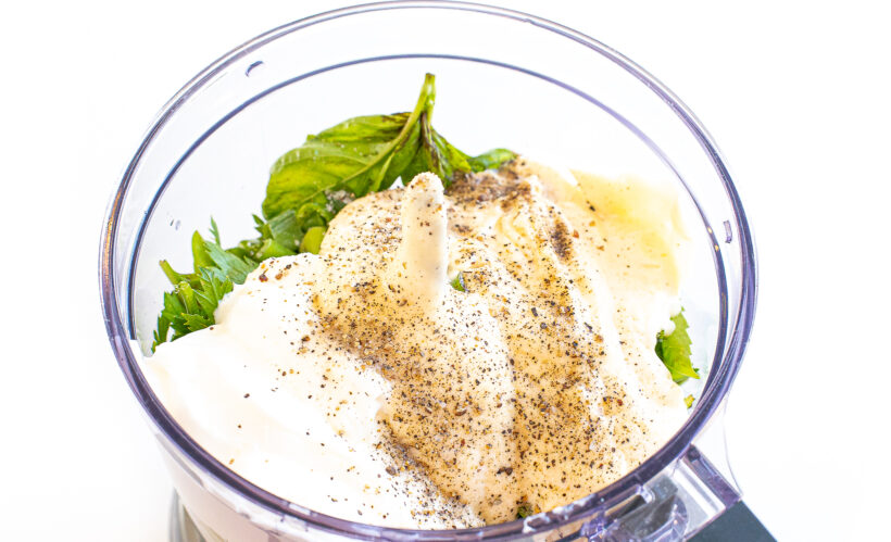 Ingredients for green goddess dressing in a food processor.