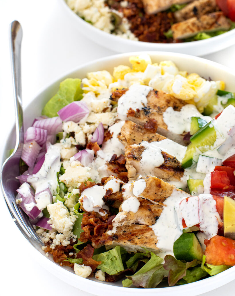 Cobb salad with ranch dressing drizzled on top.