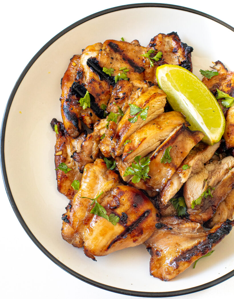 Honey lime chicken breasts garnished with cilantro and lime wedges.