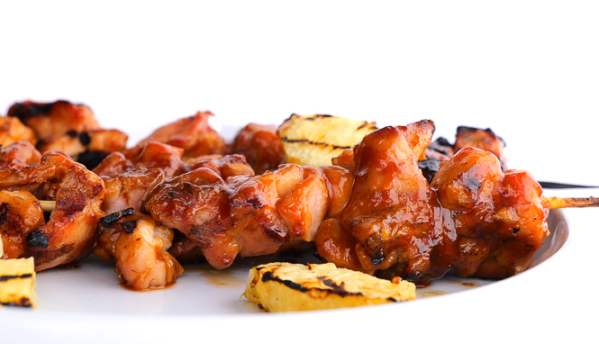 grilled cubed Pineapple chicken on white plate