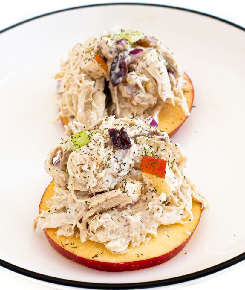 Harvest chicken salad piled on top of apple slices.