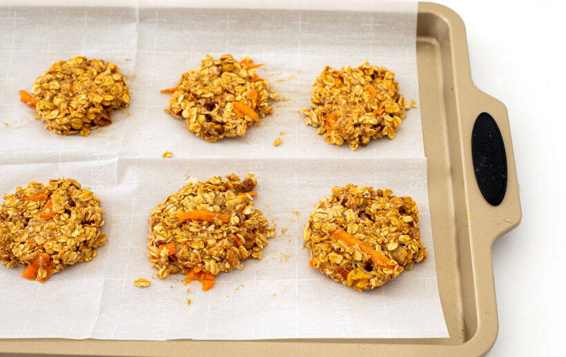 Healthy carrot cake cookies on a baking sheet lined with parchment paper before being baked. 