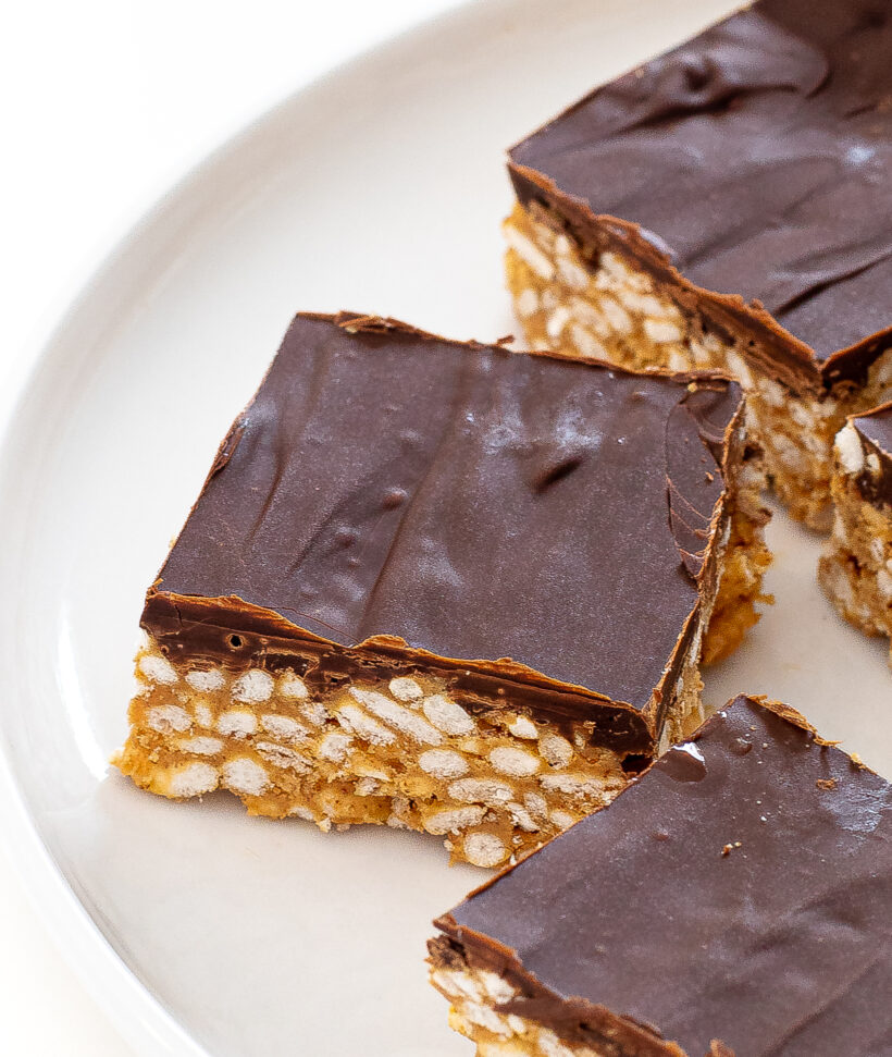 Scotcheroo bars on a white serving plate. 