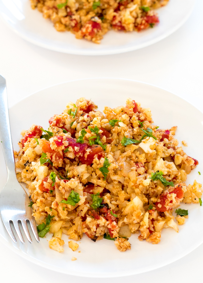 Mexican Cauliflower Rice on a white plate with a fork