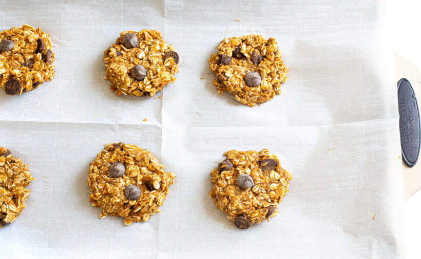 Pumpkin cookies on a baking sheet before being baked.