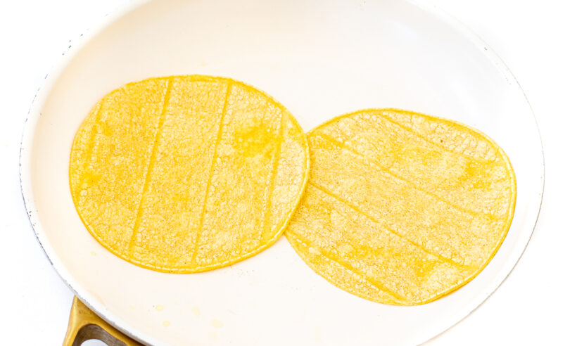 Two tortillas warmed up in a skillet.