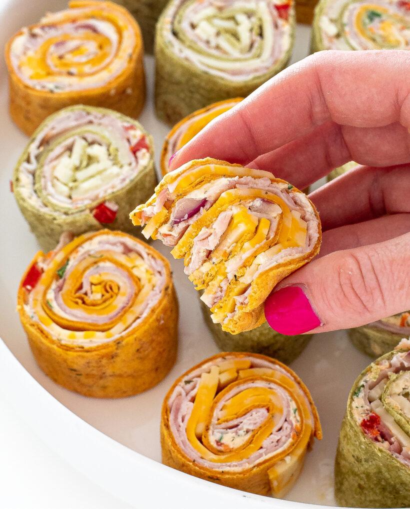 Hand holding a pinwheel with a bite taken out of it.