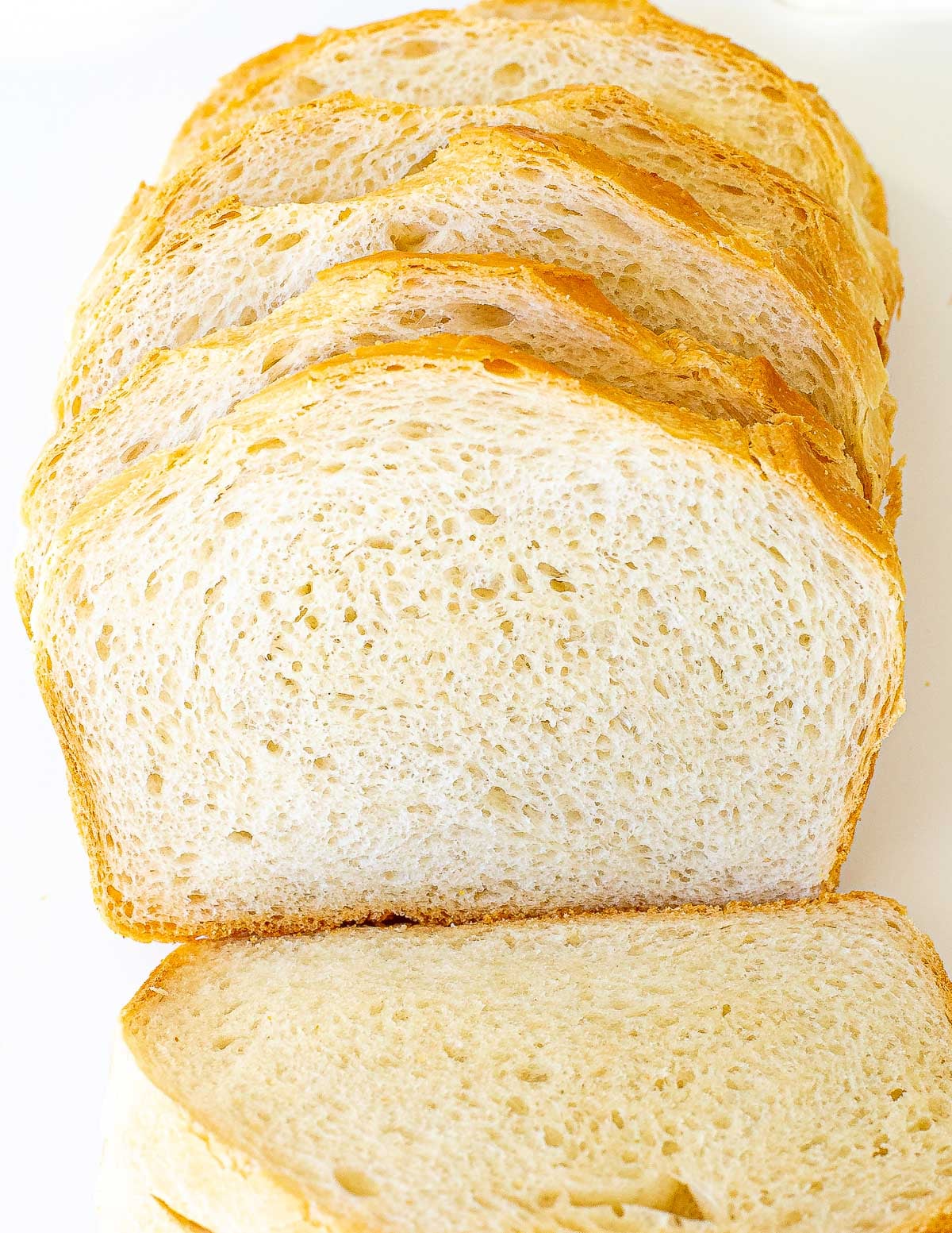 A loaf of sliced white bread, showing the interior texture and crust edges.