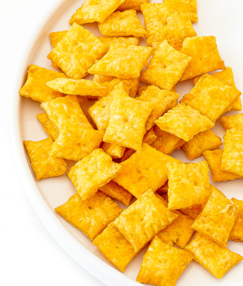 Homemade cheez it's served on a white plate. 