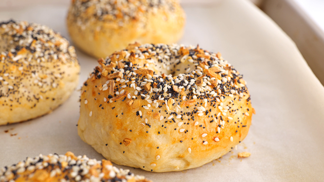 Homemade Everything Bagels on a baking tray.