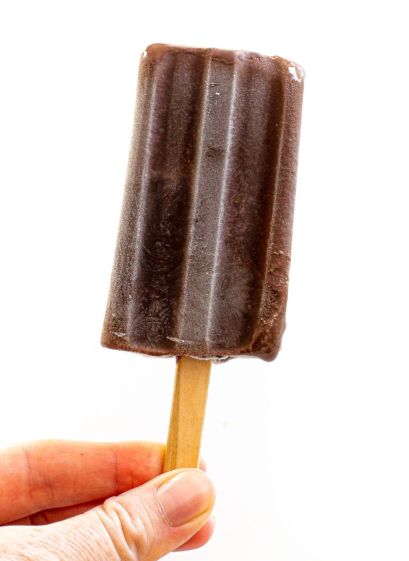 Hand holding up a homemade fudgesicle.