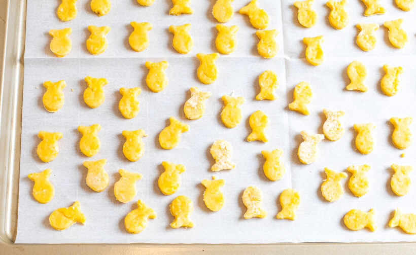 Dough cut into fish shapes and placed on a baking sheet before being baked. 