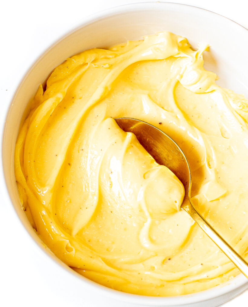 Homemade mayo in a bowl with a gold spoon.