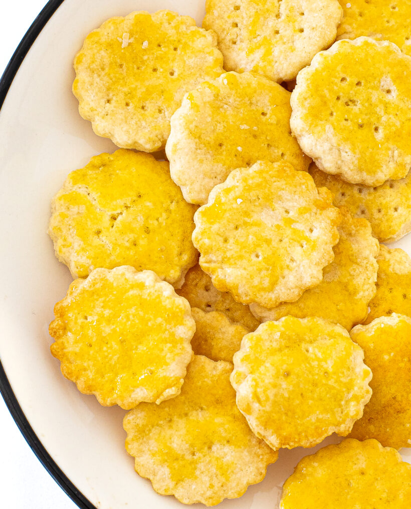 Ritz crackers piled on a white plate.