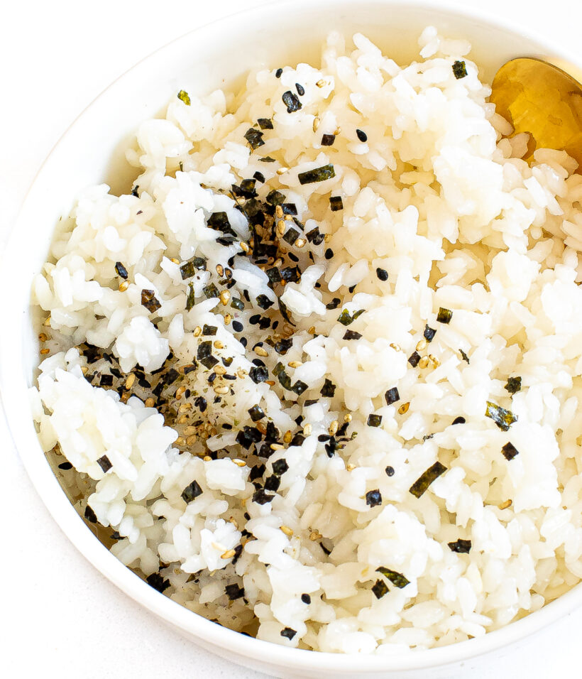 Sushi rice served in a bowl with a sprinkle of furikake on top.