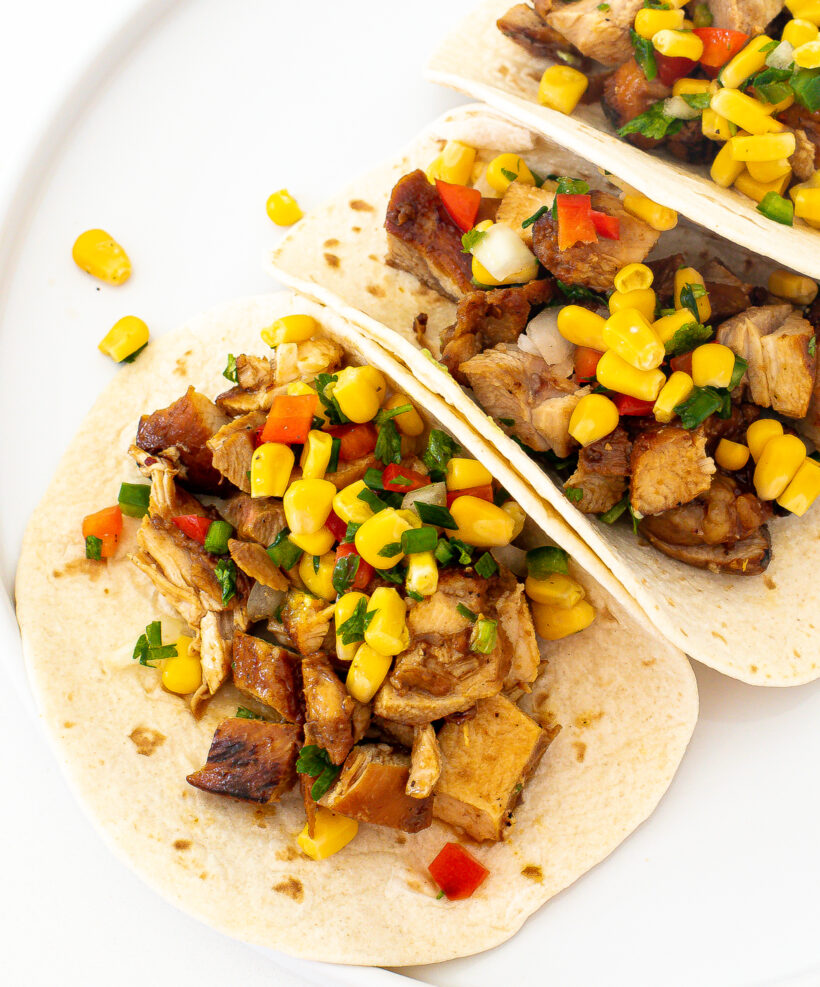 Chicken tacos with corn salsa on top.