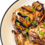 Honey lime chicken thighs on a plate.