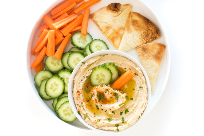 Top shot of vegetable platter with pita squares, carrots, and ground chickpeas.