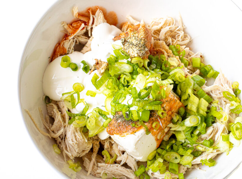 Buffalo chicken filling in a white mixing bowl.