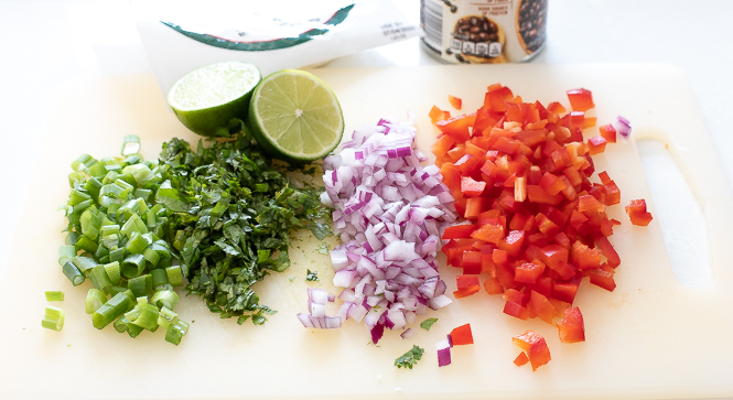 Diced vegetables on a white chopping board.