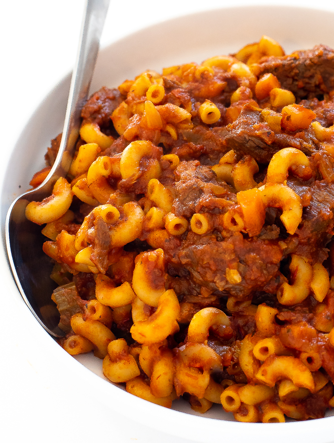 Beefaroni on a white plate with a silver spoon.