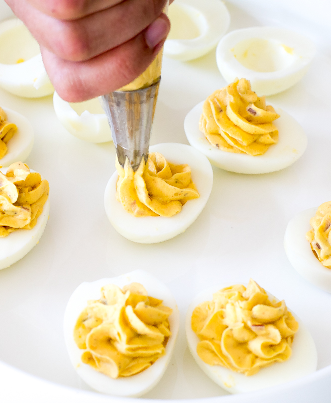 Piping deviled eggs | chefsavvy.com Piping deviled eggs on plate