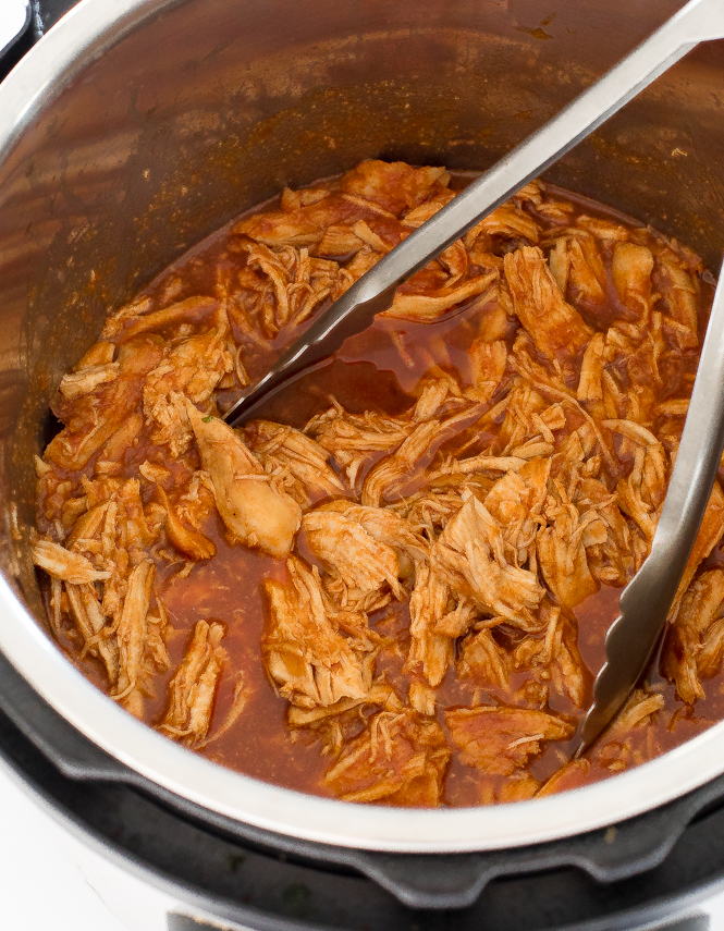 barbecue chicken in pressure cooker with tongs