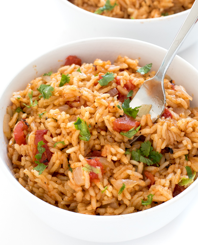Finished rice in a while bowl with a fork topped with cilantro.