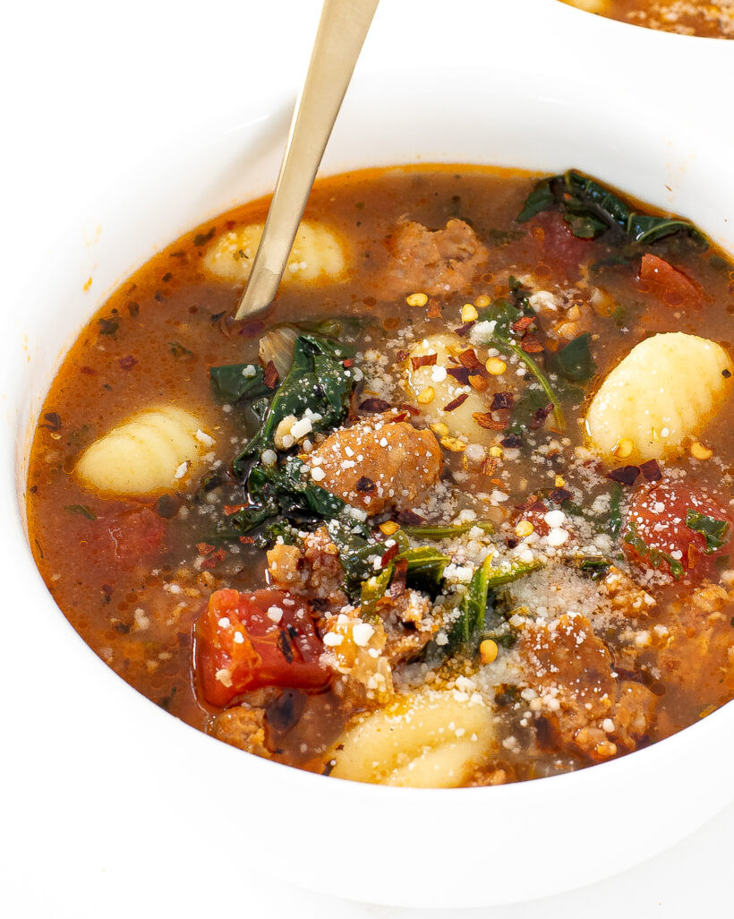 italian gnocchi soup in white bowl topped with cheese