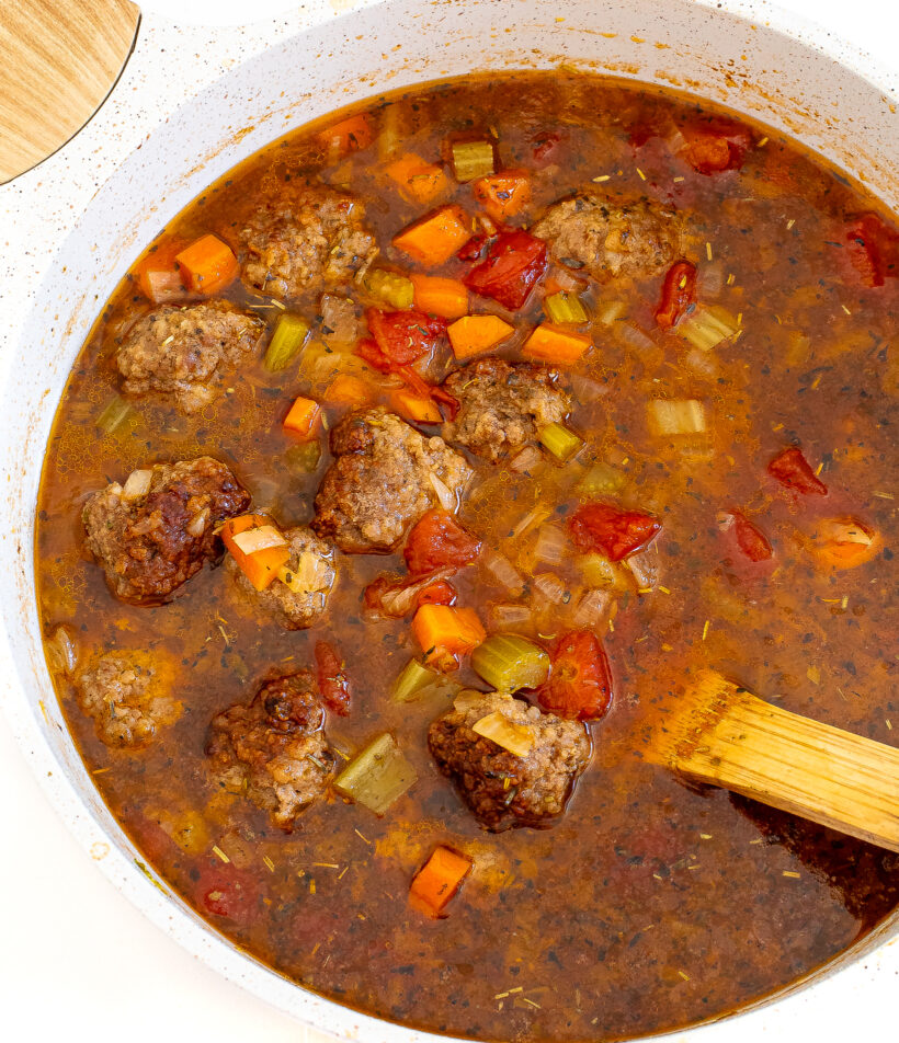 overhead shot of tomato meatball soup with veggies