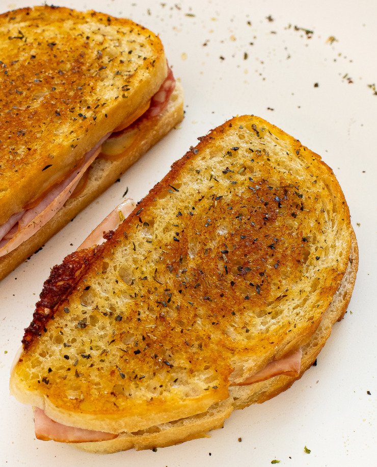 Two Italian grilled cheese sandwiches in a pan. 