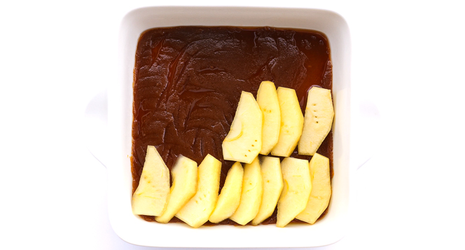 layering apple slices on top of caramel sauce