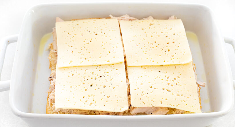 Havarti cheese layered on top of turkey in a baking dish.