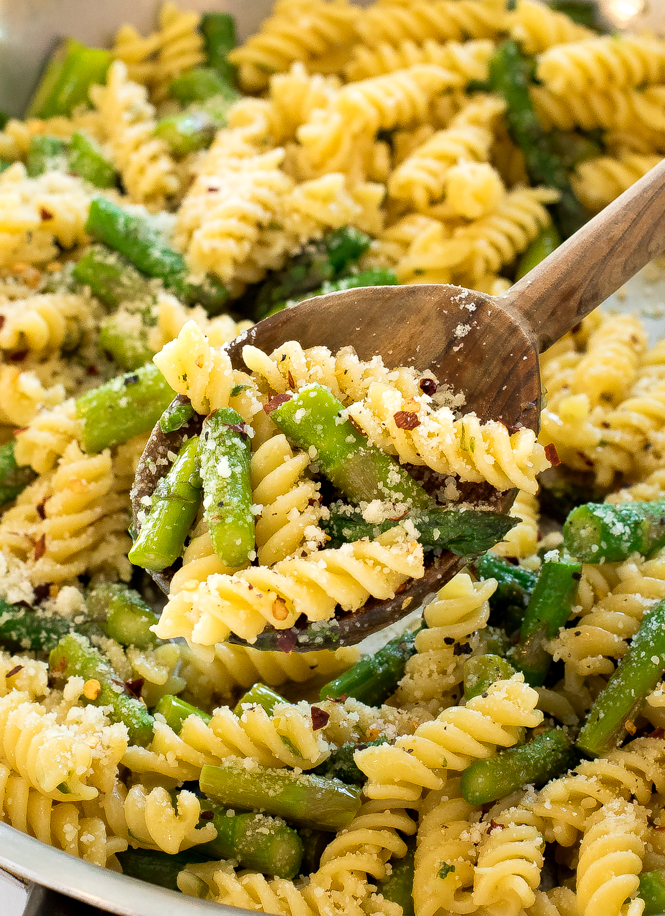 close up of this Lemon Asparagus Pasta in a large skillet with a wooden spoon