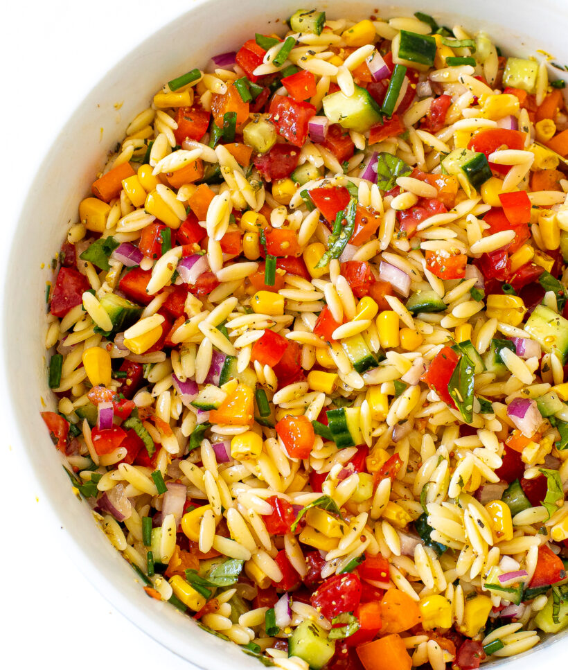 Overhead shot of summer orzo pasta salad in a large sercing bowl. 
