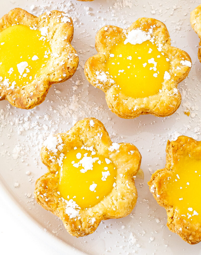 Close up shot of mini lemon tarts on a plate.