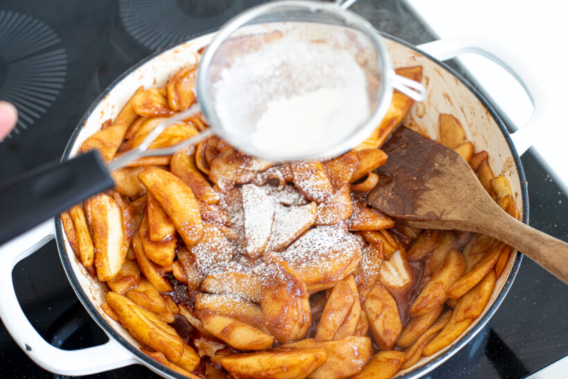 sifting flour into apple pie filling