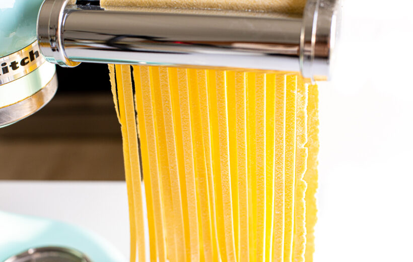 Feeding pasta dough through cutter.