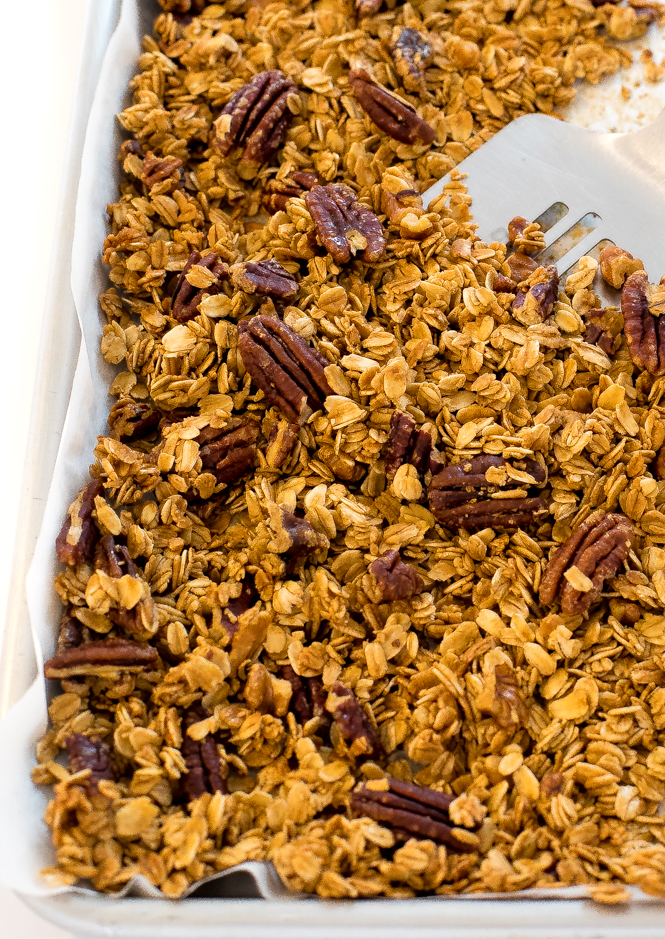 4-Ingredient Maple Pecan Granola on a baking sheet with a medal spatula This baked 4-Ingredient Maple Pecan Granola on a baking sheet with a medal spatula