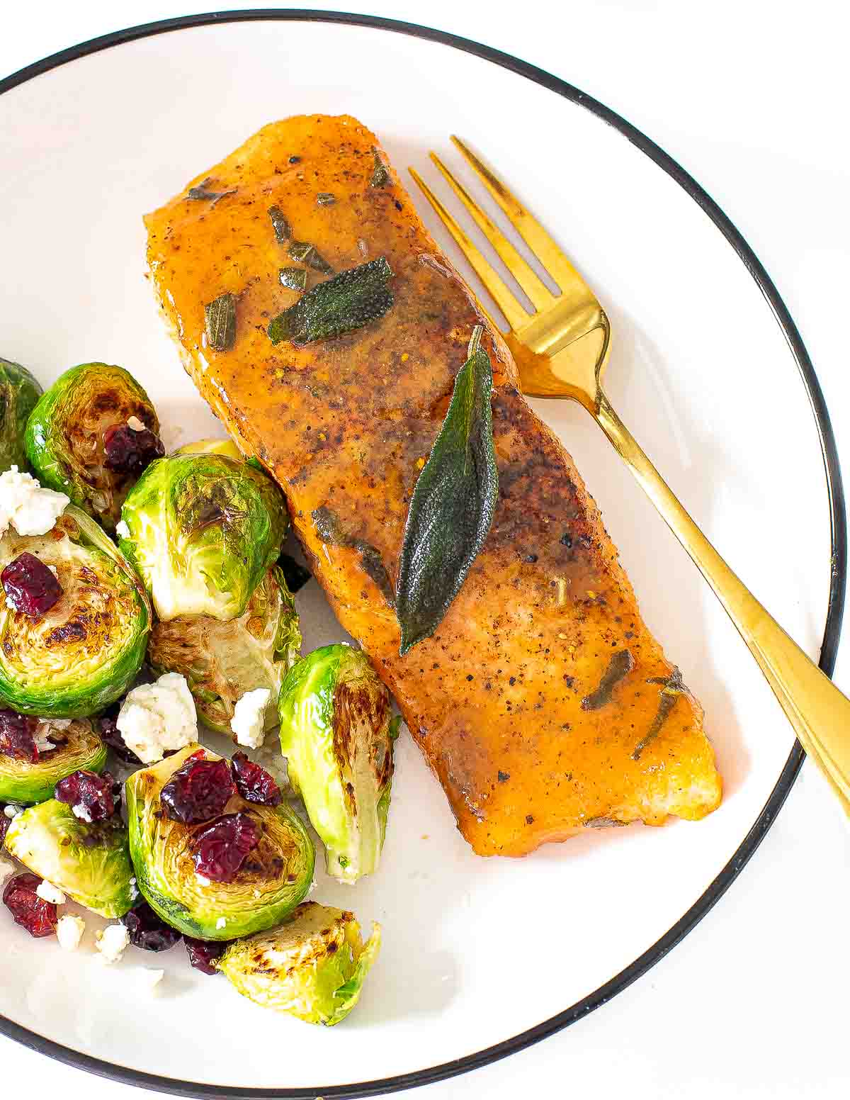 maple dijon salmon on white plate with Brussels sprouts and cranberries