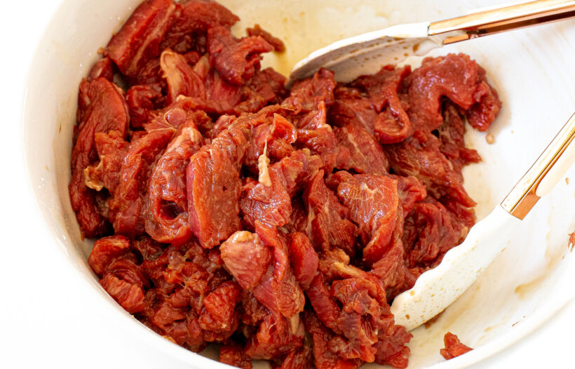 tossing flank steak in marinade