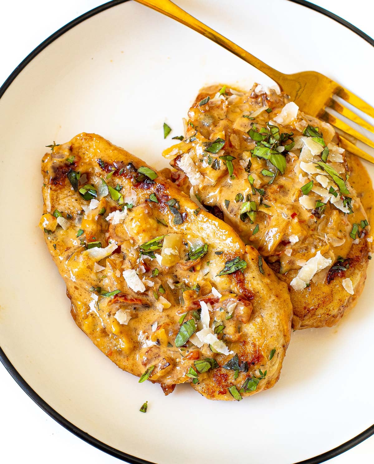 two chicken breast topped with marry me sauce on plate
